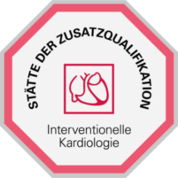 Achteckiges Schild mit rotem Rand, in der Mitte ein stilisiertes Herzsymbol und darunter der Text 'Interventionelle Kardiologie', oben im Rand steht 'STÄTTE DER ZUSATZQUALIFIKATION'