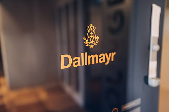 Glasfront mit goldfarbenem Schriftzug 'Dallmayr' und einem ornamental gestalteten Logo darüber