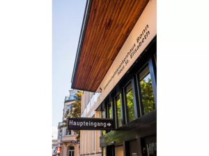 Außenansicht eines Gebäudes mit einem Schild 'Haupteingang' und der Aufschrift 'Gemeinschaftskrankenhaus Bonn Haus St. Elisabeth' an der Fassade
