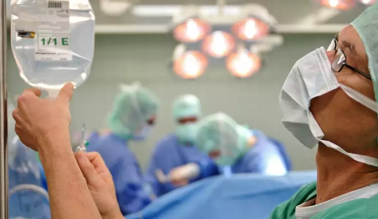 Arzt überprüft Tropf im OP