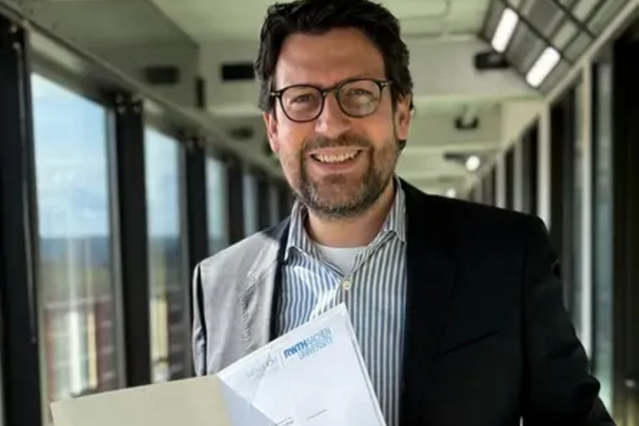 Mann in Anzug hält Dokument in einem modernen Büroflur