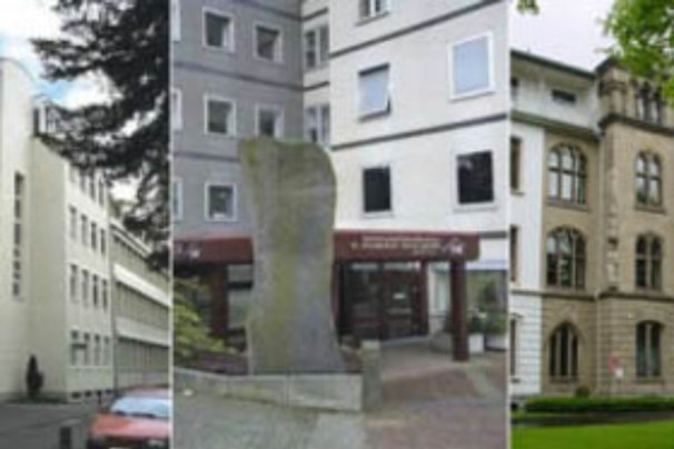 Steinerne Gedenksäule auf einem Platz zwischen modernen und historischen Gebäuden in einer Stadt