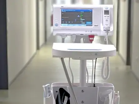 Medizinisches Überwachungsgerät auf einem Rollwagen in einem Krankenhausflur