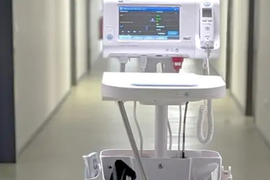 Medizinisches Überwachungsgerät auf einem Rollwagen in einem Krankenhausflur