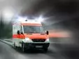 Rettungswagen mit eingeschaltetem Blaulicht fährt auf einer Straße