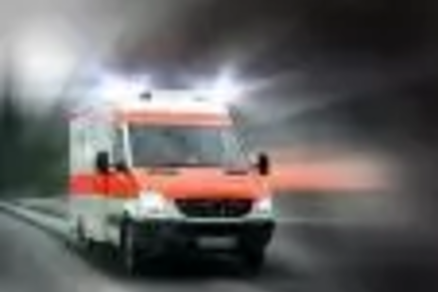 Rettungswagen mit eingeschaltetem Blaulicht fährt auf einer Straße